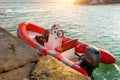 Red rescue inflatable boat moored to the sea pier, closeup. Empty marine rescue boat Royalty Free Stock Photo