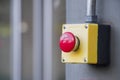 Red Reset button on the wall. red emergency stop switch button in a factory building