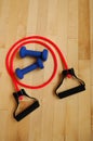 Red Resistance Band and Blue Weights on Gym Floor Royalty Free Stock Photo