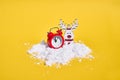 Red retro alarm clock with snow on yellow background. Creative Christmas or New year concept.