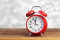 Red retro alarm clock on white bokeh abstract background