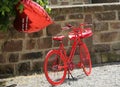 Red retro bike infront of a castle wall with a red ballon in background