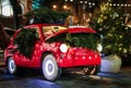 Red retro car with gift boxes and christmas tree on street night in Paris. Christmas and New Year street decoration festive Royalty Free Stock Photo