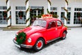 Red retro car standing in backyard. Volkswagen beetle. New year presents Royalty Free Stock Photo