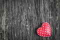 Red retro heart with white polka dot pattern on wooden background with vintage and vignette tone