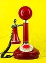 Red retro phone on yellow background Vintage old-fashioned telephone device on bright modern pastel color fabric surface Royalty Free Stock Photo