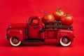Red retro pickup truck carries fresh tomatoes on a red background, harvesting, and creative presentation of the product