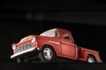 Red retro pickup truck, toy, close-up on black background