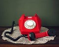 Red retro rotary phone on a lacy napkin. Royalty Free Stock Photo