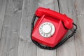 Red retro rotary phone on a wooden platform. Royalty Free Stock Photo