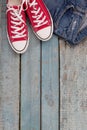 Red retro sneakers and jeans on a blue wooden background Royalty Free Stock Photo