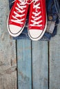Red retro sneakers and jeans on a blue wooden background Royalty Free Stock Photo