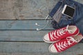 Red retro sneakers and smartphone with headset-earphones in a po Royalty Free Stock Photo