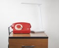 Red retro telephone on wooden nightstand Royalty Free Stock Photo