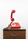 Red retro telephone on wooden nightstand Royalty Free Stock Photo