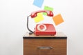 Red retro telephone on wooden nightstand Royalty Free Stock Photo