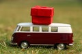 Red retro toy car with gift box. Flowers, gifts delivery concept.