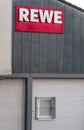 Red REWE label outside on a gray building Royalty Free Stock Photo