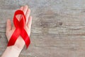 Red Ribbon - AIDS awareness symbol on the wooden background with Royalty Free Stock Photo