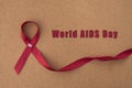 Red ribbon aids ribbon on notice board with `World Aids Day` word.