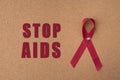 Red ribbon aids ribbon on notice board with `Stop Aids` word.