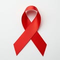 A red ribbon is arranged in a loop with a diagonal cross at the front, set against a plain