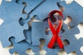 A red ribbon on a background of scattered jigsaw puzzles