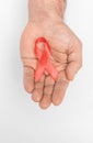 Red ribbon bow awareness on mans hand isolated on white background. HIV, AIDS world day. Social life issues concept Royalty Free Stock Photo