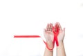 Red ribbon bow on hold hand isolate white background Royalty Free Stock Photo