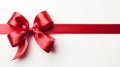 Red ribbon bow on left of long ribbon for banner, isolated on white background with copy space Royalty Free Stock Photo