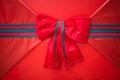 Red ribbon bow with tails on gift box. Royalty Free Stock Photo