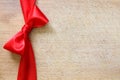 Red ribbon and bow on vintage cutting board christmas background