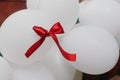 Red ribbon on bunch of white decorative air baloons, balloons we