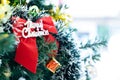 Red ribbon on the Christmas pine tree as a symbolic sign to say Merry Christmas