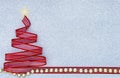 Red ribbon Christmas tree with golden bead on silver glitter texture background Royalty Free Stock Photo