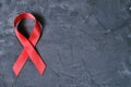 Red ribbon on concrete texture background, symbol of AIDS disease and drug abuse problem