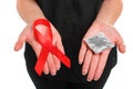 Red ribbon and a condom on female hands isolated on a white background. AIDS Awareness. Healthcare and medicine concept Royalty Free Stock Photo