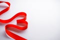 Red ribbon in the form of a heart on a white background with place for text Royalty Free Stock Photo