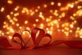 Red ribbon hearts against defocued lights on red background. Valentines day or wedding celebration concept. Copy space. Soft focus Royalty Free Stock Photo