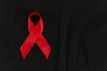 Red ribbon HIV, AIDS symbol frame top view on a black fabric background with copy space Royalty Free Stock Photo