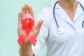 Red ribbon for HIV illness awareness in doctor`s hand, 1 December World AIDS Day concept. Royalty Free Stock Photo