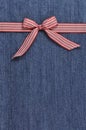 Red ribbon on a jeans background