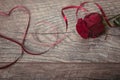 The red ribbon is lined in the shape heart on a dark wooden table. Valentines day background, rustic style. Valentines day table p Royalty Free Stock Photo