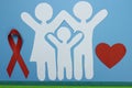 Red Ribbon and Paper silhouette of family. AIDS awareness symbol Royalty Free Stock Photo