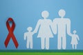 Red Ribbon and Paper silhouette of family. AIDS awareness symbol Royalty Free Stock Photo