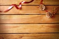 Red ribbon and pinecone Christmas decoration on wooden table top Royalty Free Stock Photo