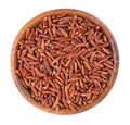Red rice isolated in wooden bowl, on white background. Whole grain raw brown rice. Top view. Royalty Free Stock Photo
