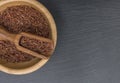 Red rice and olive wood scoop in a wooden bowl on black background of slate or stone Royalty Free Stock Photo
