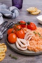 Red rice with seafood tentacles and tomatoes