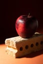 Red ripe apple on a brick. Creative photo in shadows.
